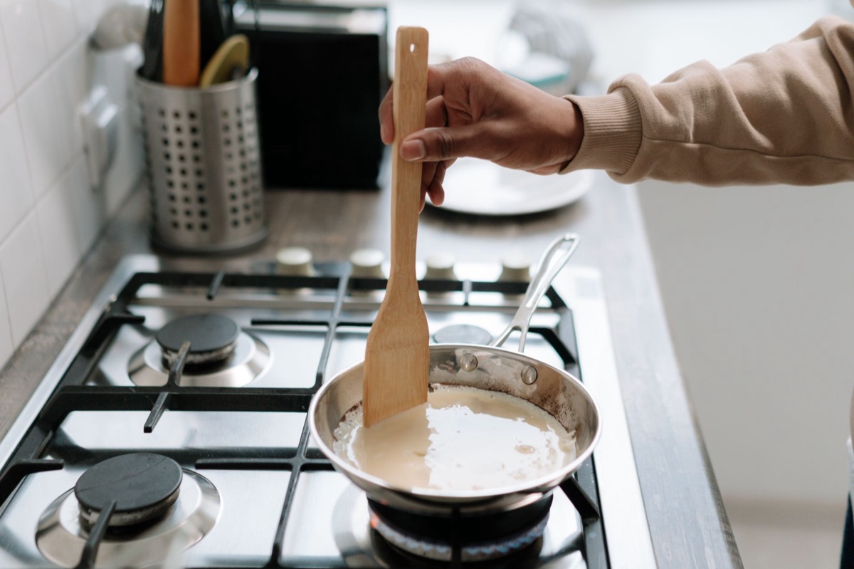 Processo de emulsão da massa com molho em uma frigideira.