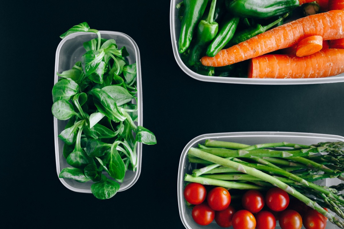 A glass meal prep container filled with chicken salad and fresh vegetables