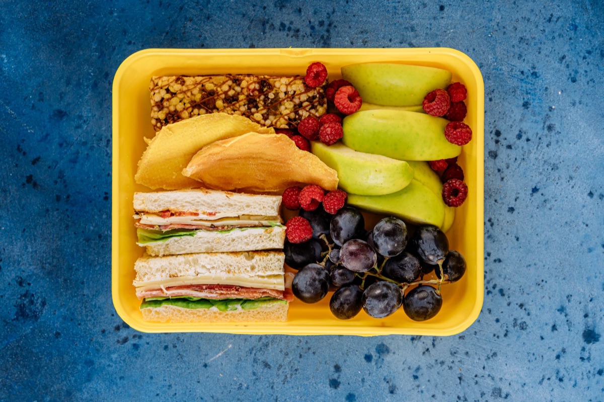 Un almuerzo saludable con ensalada y granos en un recipiente individual.