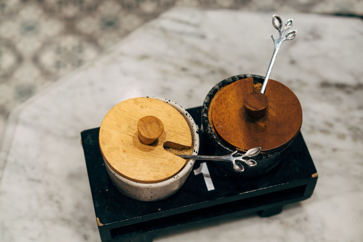 A spoon dipping into a pot of soup to check seasoning.