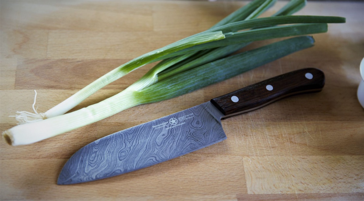 Ein Set aus essenziellen Küchenutensilien wie Messer, Schneidebrett und Kochlöffel.
