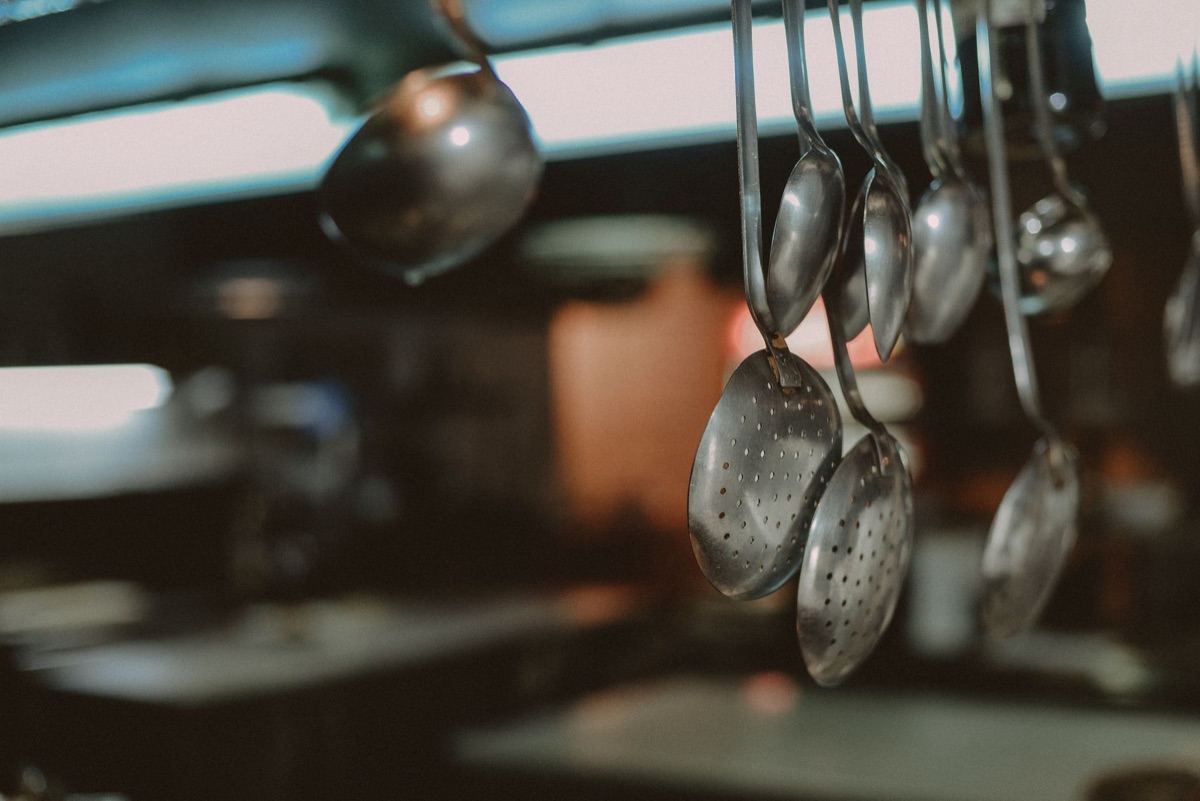 Une casserole en acier inoxydable et une cuillère en bois sur une cuisinière.