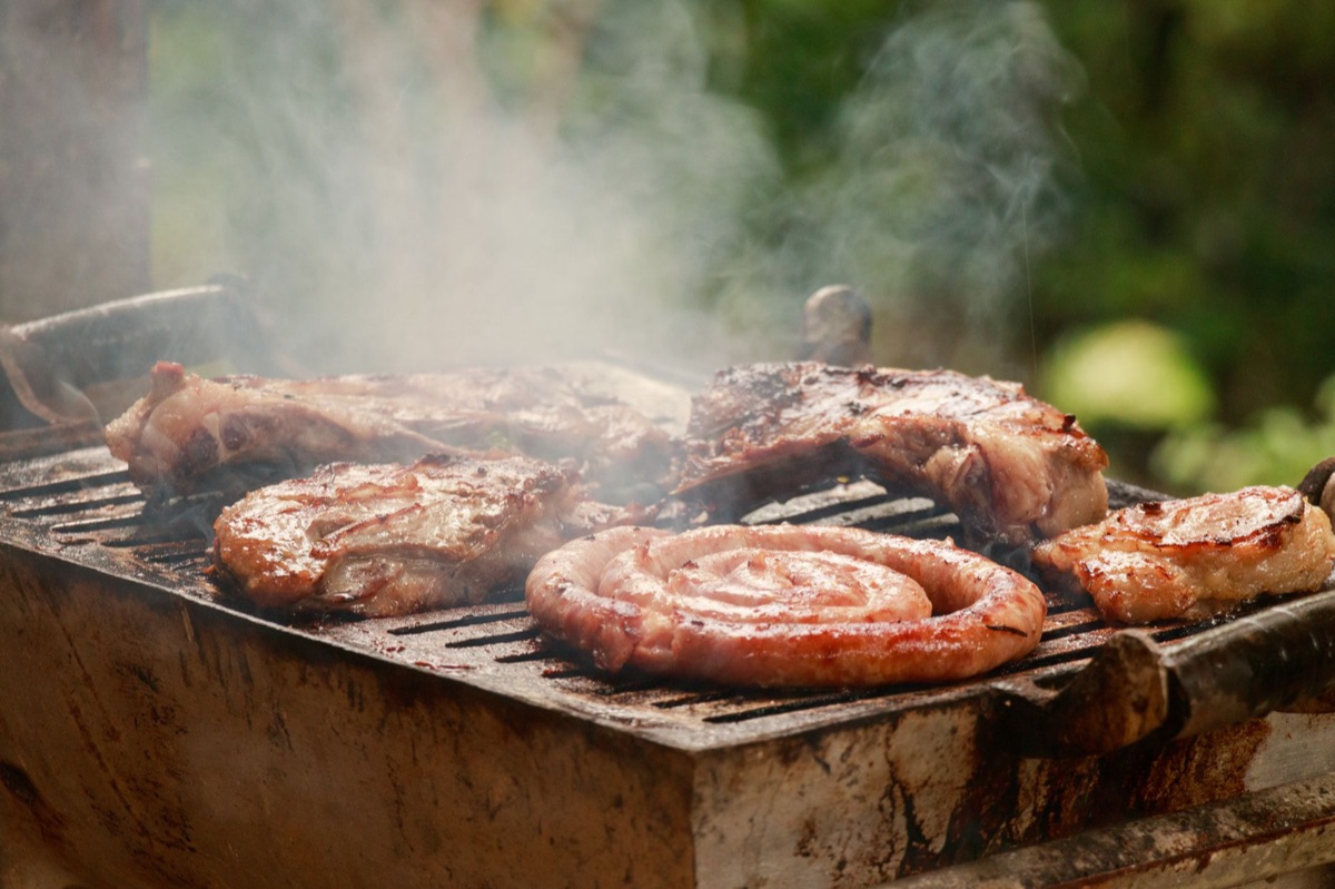 Termômetro digital medindo a temperatura interna da carne.
